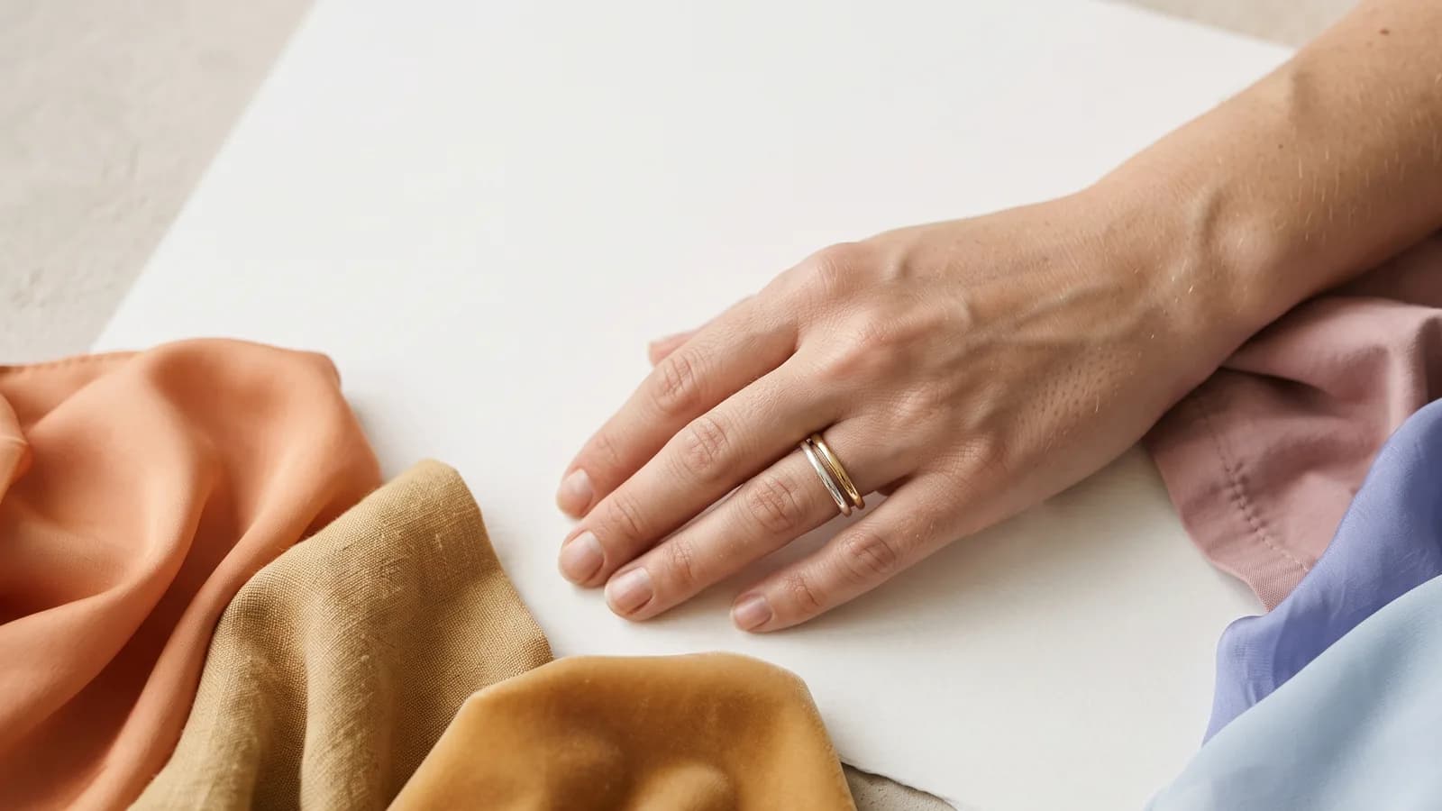 Inner wrist and palm in soft, neutral daylight beside a sheet of plain white paper